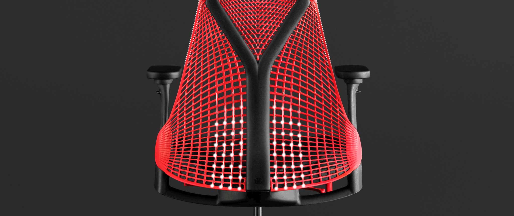 Vue arrière d'un fauteuil de jeu Sayl rouge et noir de Herman Miller, superposé à des graphiques blancs mettant en évidence le dossier suspendu.