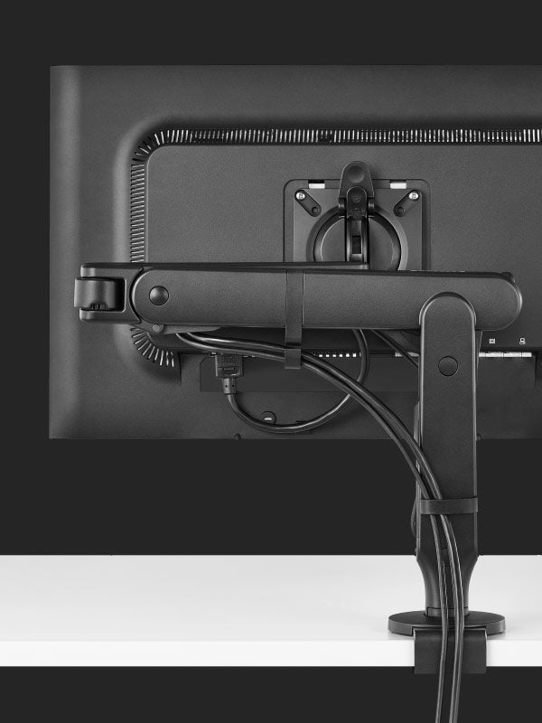 Vue arrière d'un bras de moniteur de jeu Ollin noir de Herman Miller, montrant la fonction de gestion des câbles.