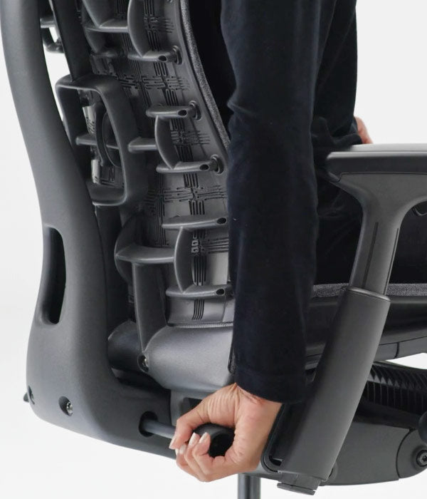 Vue arrière rapprochée du réglage du soutien lombaire utilisé sur la chaise Embody en noir
