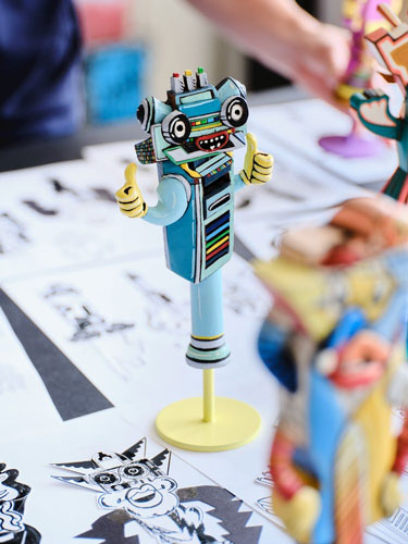 Vue rapprochée d'une sculpture bleue et jaune de FAILE et Deluxx Fluxx.