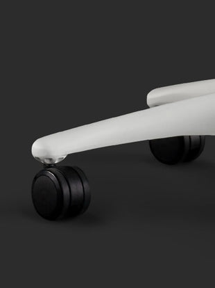 Gros plan d'une chaise de jeu Embody blanche de Herman Miller, montrant les roulettes noires.