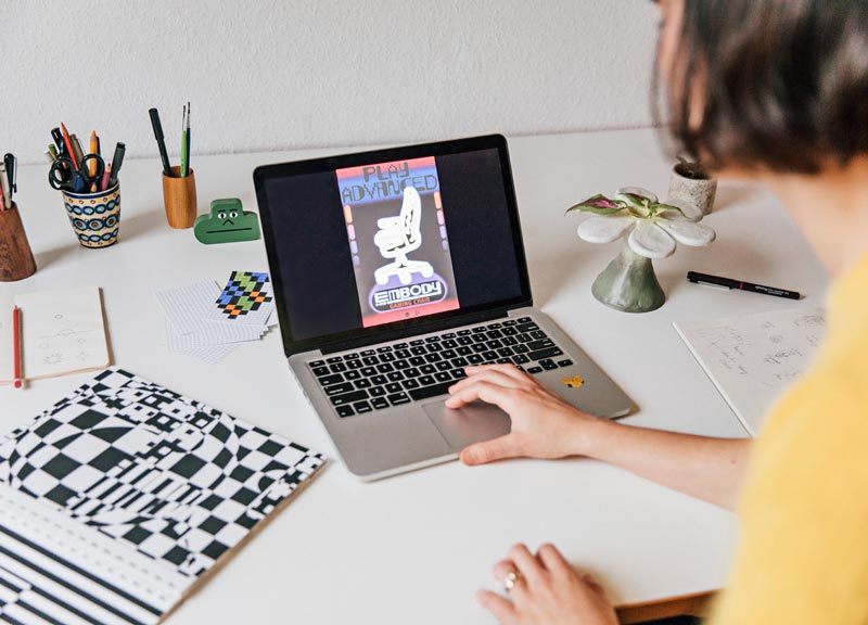 Gros plan de la version finale de l'affiche de la chaise de jeu Embody sur l'ordinateur portable de Molly Rose Dyson
