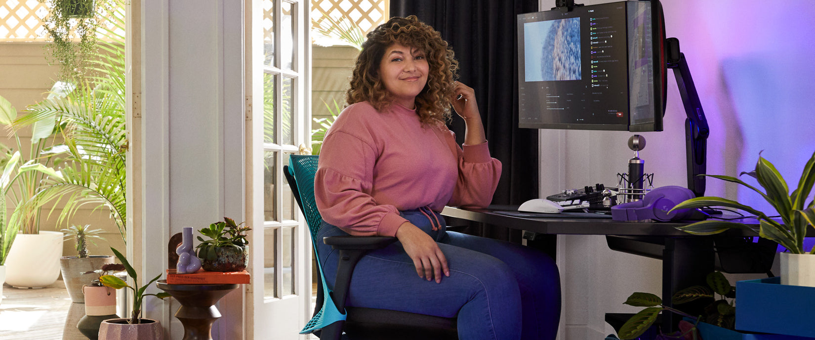 Photo du pro-gamer et doubleur Friskk assis dans un fauteuil gaming Sayl noir et bleu océan profond avec un bureau gaming Nevi noir.