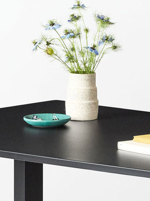 Vue latérale en gros plan d'un bureau debout Jarvis en stratifié de Herman Miller, montrant la texture et la finition du plan de travail.