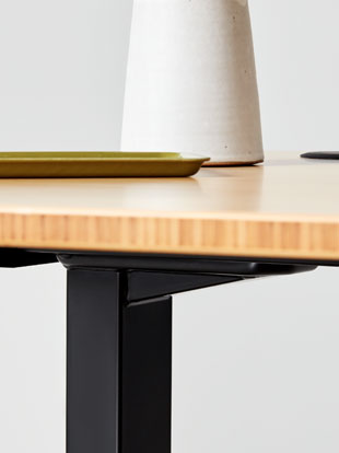 Vue latérale en gros plan d'un bureau debout Jarvis en bambou d'Herman Miller, montrant la texture et la finition du plan de travail.