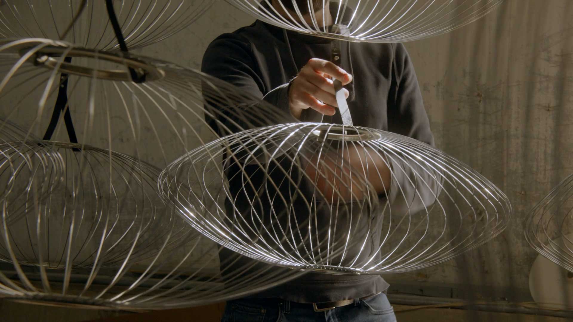 Un artisan expérimenté fabriquant les structures métalliques d'une sélection d'abat-jour Nelson Bubble.