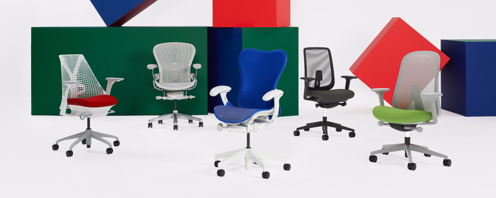 Une gamme de fauteuils de bureau Herman Miller dans un studio, comprenant les modèles Sayl, Aeron, Mirra 2, Verus et Lino dans une variété de couleurs.