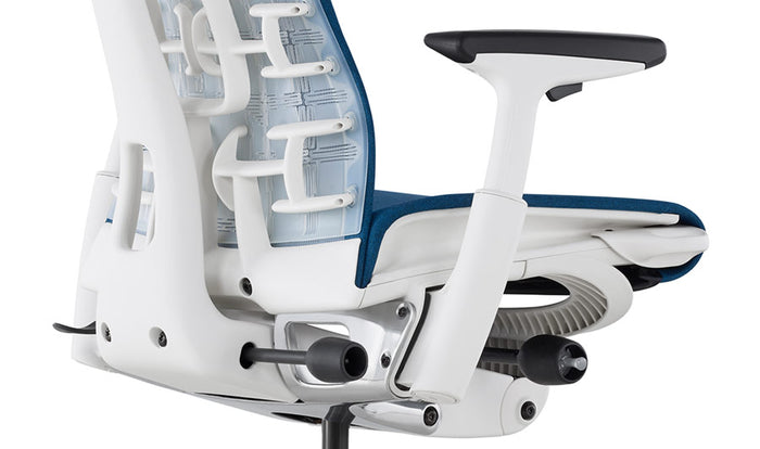 Gros plan d'une chaise de bureau Embody blanche et bleue de Herman Miller, montrant l'arrière du dossier.