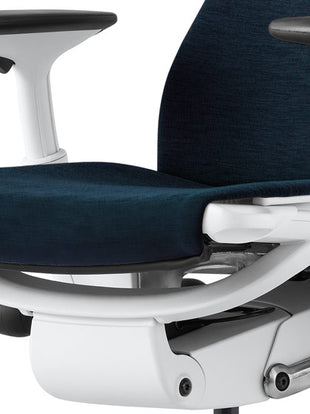 Gros plan d'une chaise de bureau Embody blanche et bleue de Herman Miller, montrant l'assise profilée.