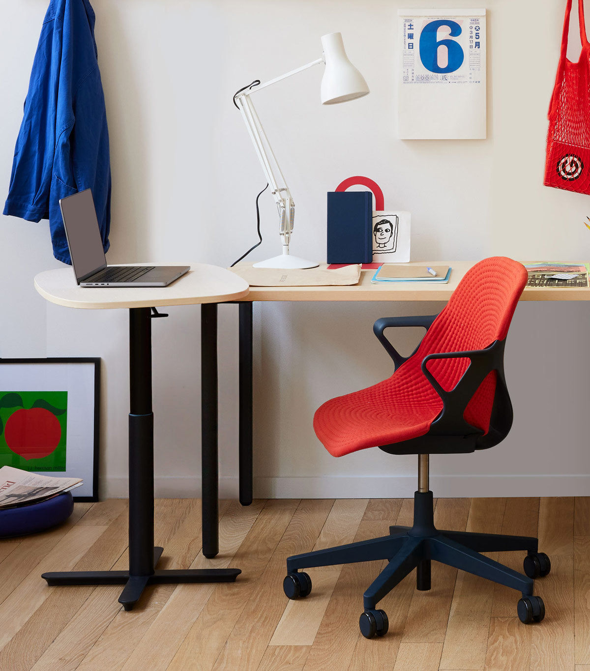 Espace de bureau à domicile avec un siège de bureau Zeph en carbone avec une housse rouge vif, un bureau OE1 et une table de travail portable Passport
