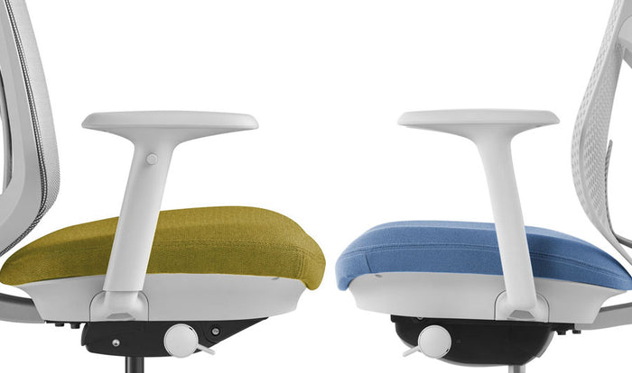 Vue latérale de deux chaises de bureau Verus de Herman Miller se faisant face. La chaise de gauche présente l'accoudoir entièrement réglable et la chaise de droite l'accoudoir fixe.