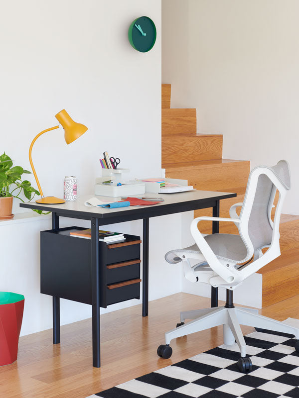 Bureau à domicile avec un bureau Mode à hauteur fixe avec tiroirs de rangement et une chaise de bureau Cosm à dossier bas blanc avec divers accessoires de bureau.