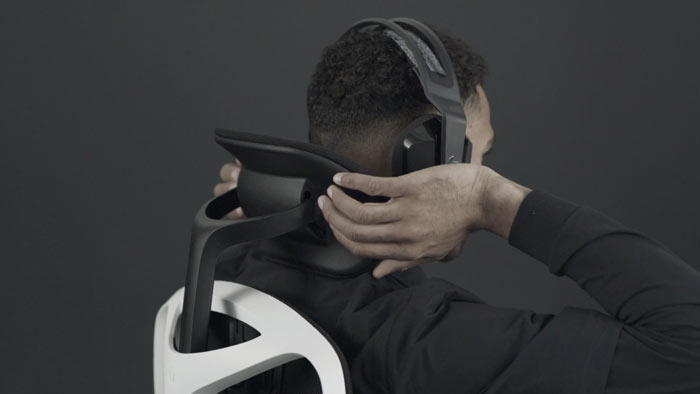 Vidéo d'une personne assise dans un fauteuil de jeu Vantum blanc et noir de Herman Miller, qui tend la main derrière le fauteuil pour régler l'appui-tête.