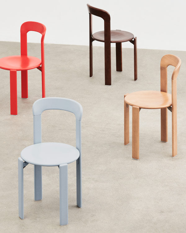 Photo de groupe de quatre chaises Rey de HAY, montrant les différentes options de couleurs. Prise dans un environnement intérieur avec un sol en béton et des murs blancs.