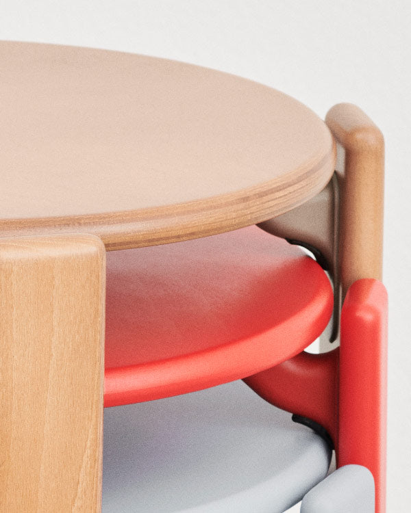 Gros plan sur trois chaises Rey de HAY, en hêtre, rouge et bleu, empilées les unes sur les autres.