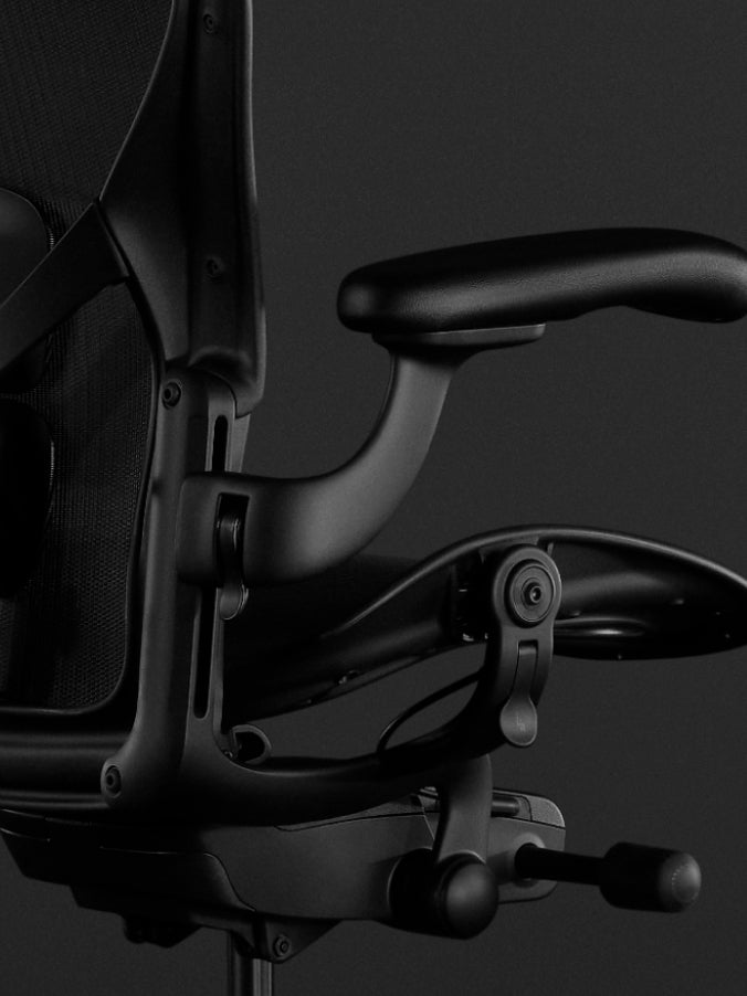 Vue latérale d'un fauteuil de jeu Aeron noir de Herman Miller, montrant la fonction d'inclinaison.