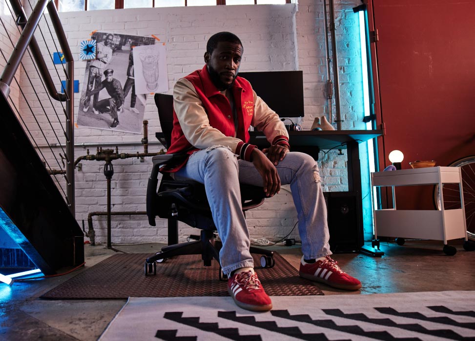 Photo de Deansocool, membre de l'équipe G2 Esports, assis dans un fauteuil G2 Embody, dos tourné vers son installation de jeu comprenant un bureau gaming Nevi noir et des écrans Ollin