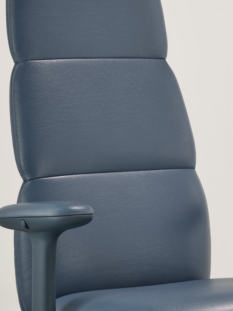Gros plan d'un siège de bureau Asari en cuir bleu de Herman Miller, montrant la technologie interne Posturefit intégrée.
