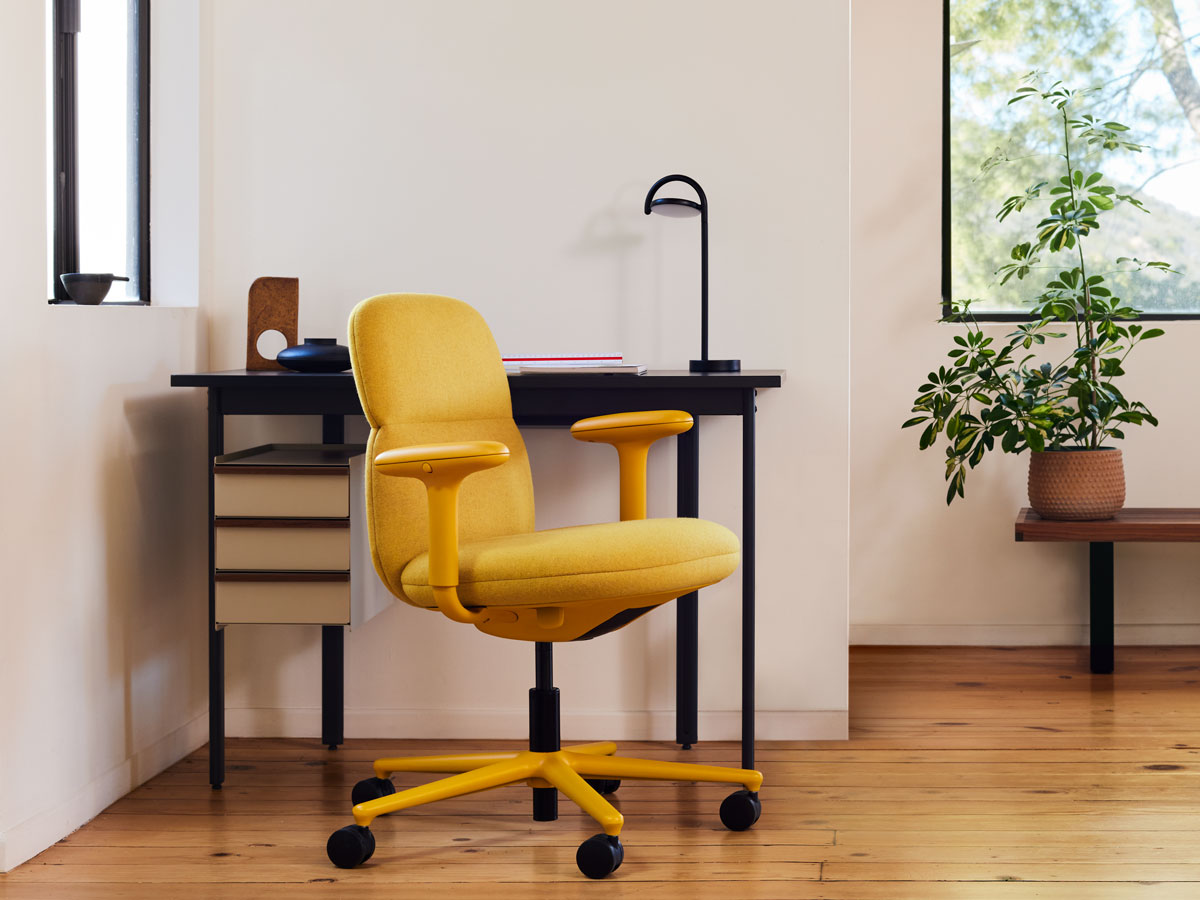 Un siège Asari jaune par Herman Miller, recouvert de tissu Clarion Luce par Maharam, avec un bureau Mode et une lampe Marselis