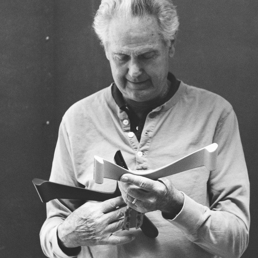 Photo en noir et blanc de Don Chadwick tenant des composants de fauteuils.