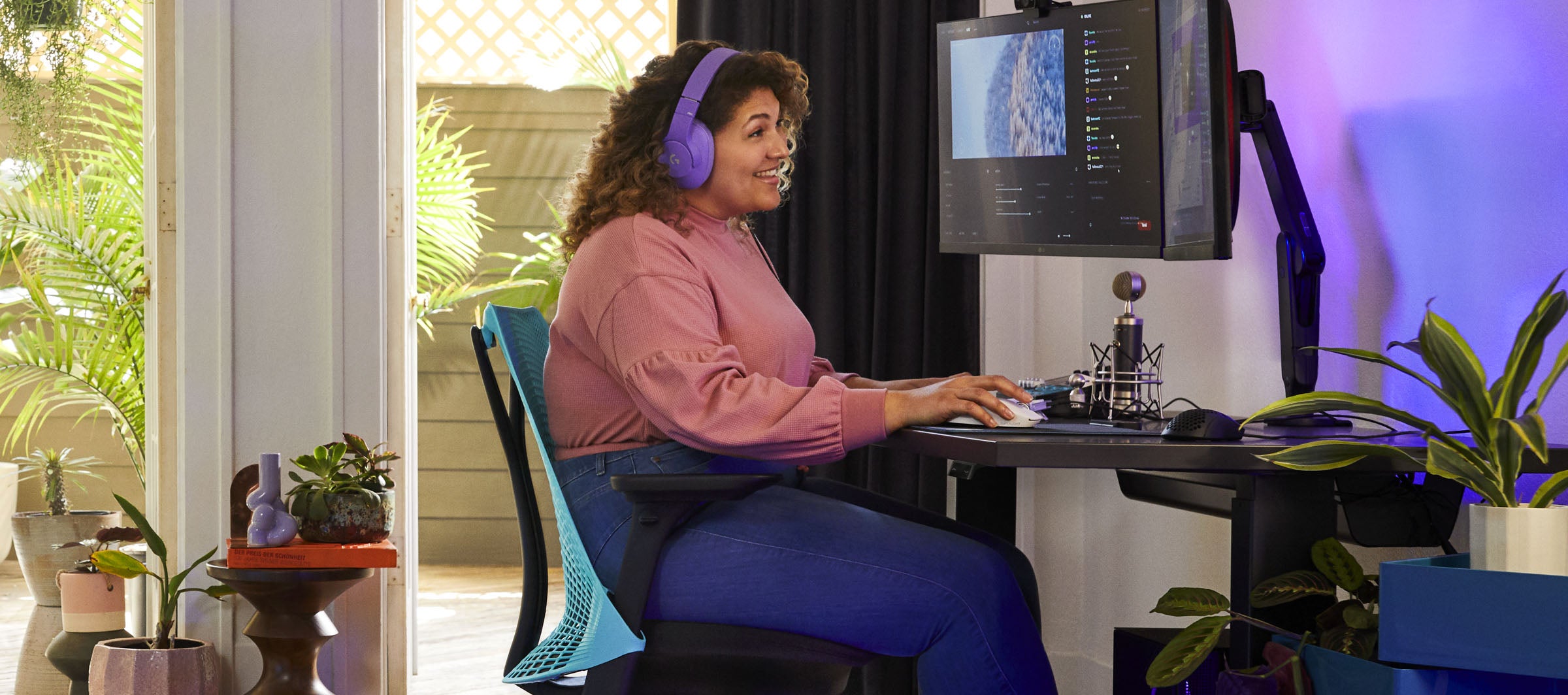 Photo de Friskk assis sur Sayl en noir et bleu océan profond avec un bureau de jeu Nevi en noir