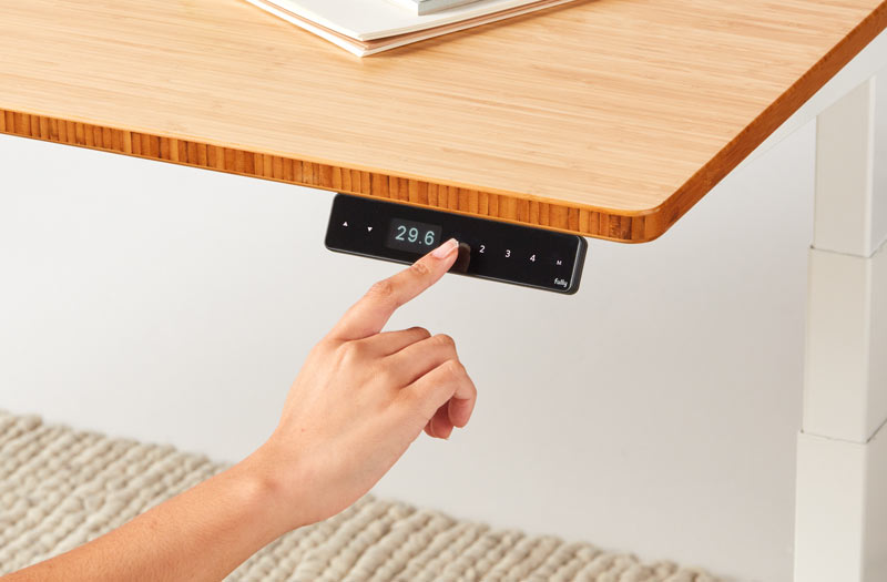 Collage de deux images en gros plan, représentant une main qui touche le bouton haut/bas et le module programmable permettant de régler la hauteur d'un bureau debout Jarvis de Herman Miller.