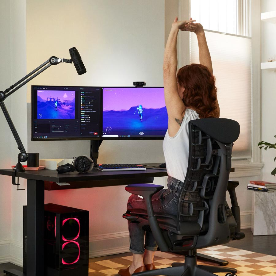 La docteure Lindsey Migliore, spécialiste de l'e-sport, devant un équipement de jeu avec deux écrans sur des bras pour moniteur Ollin