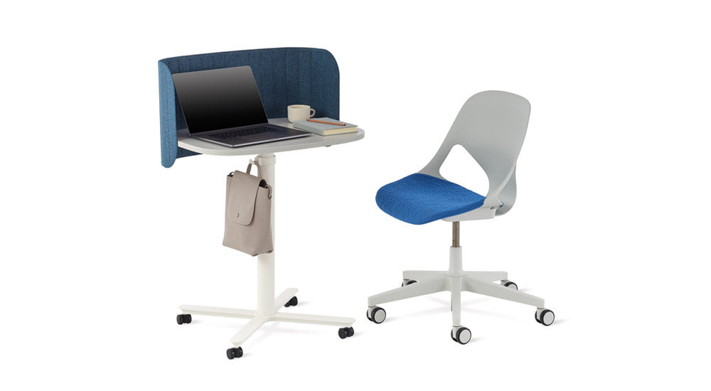 Table de travail Passport blanche de Herman Miller avec un écran de bureau Passport bleu. Elle est placée à côté d'une chaise de bureau Zeph grise et bleue.