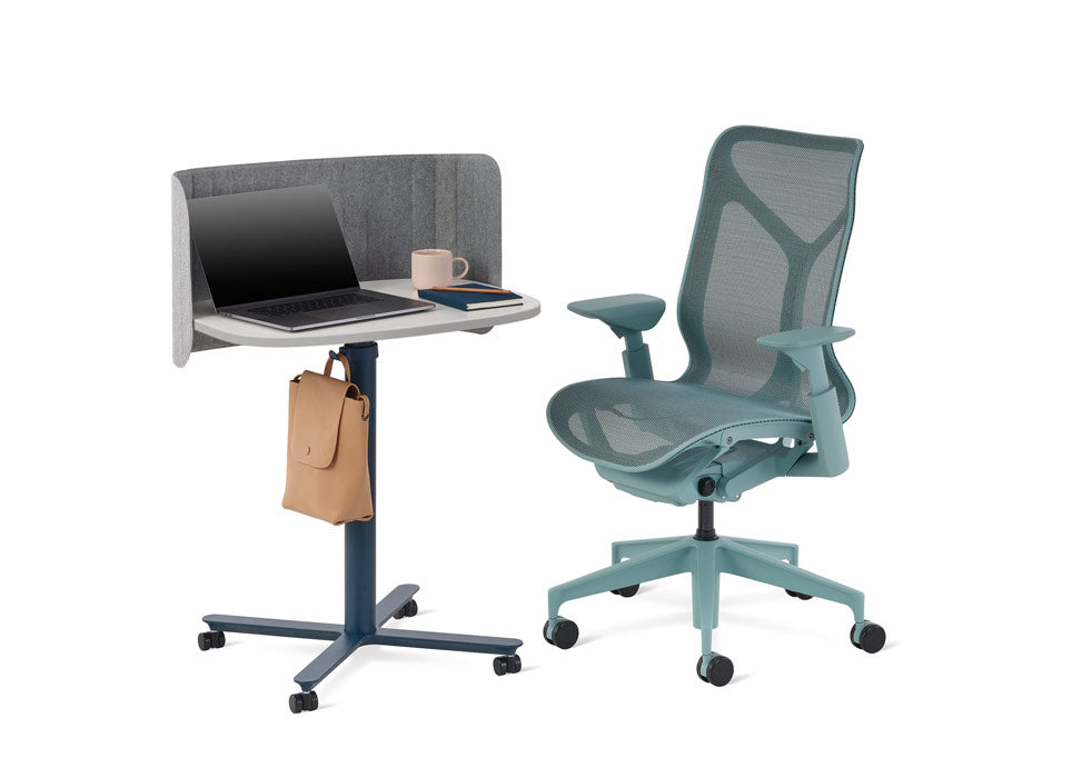Un fauteuil de bureau Cosm bleu d'Herman Miller placé à côté d'une table Passport bleue et blanche d'Herman Miller.