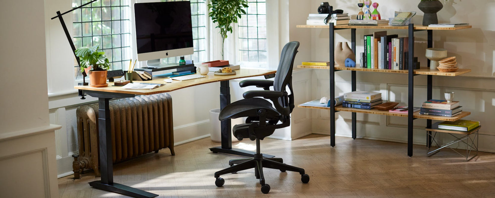 Bureau à domicile avec la chaise emblématique Herman Miller Aeron en noir onyx et un bureau Jarvis assis-debout avec des pieds et un plateau en bambou profilé.