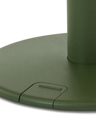 Gros plan sur un bureau debout OE1 vert de Herman Miller, montrant la pédale de commande haut/bas actionnée au pied.