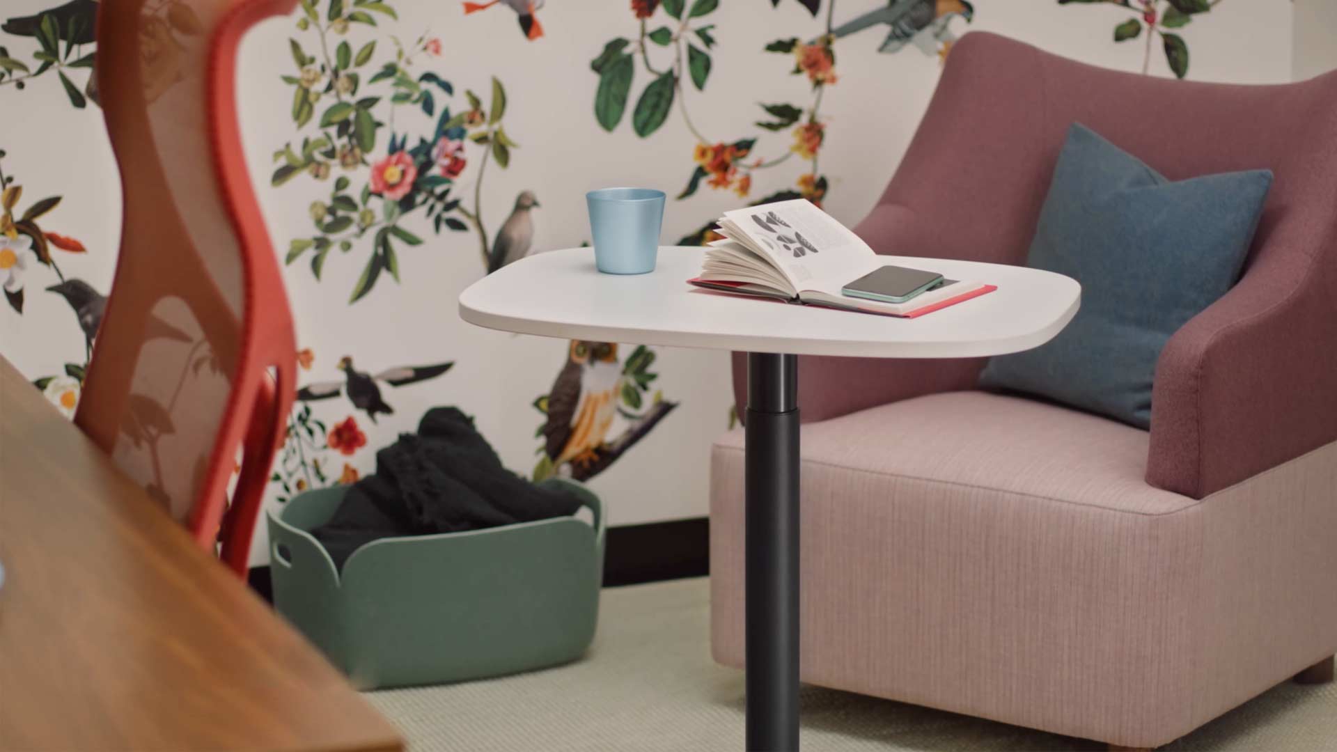 Vidéo d'une femme assise dans un fauteuil Wilkes jaune et utilisant une table Passport de Herman Miller. La vidéo continue de montrer l'utilisation de la table Passport dans un certain nombre d'endroits, y compris dans des bureaux et des environnements domestiques.