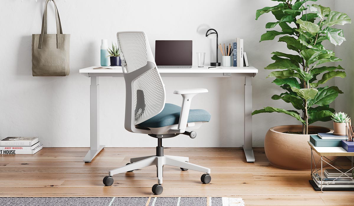 Un siège de bureau Verus blanc et bleu d'Herman Miller, placé devant un bureau debout Nevi blanc.