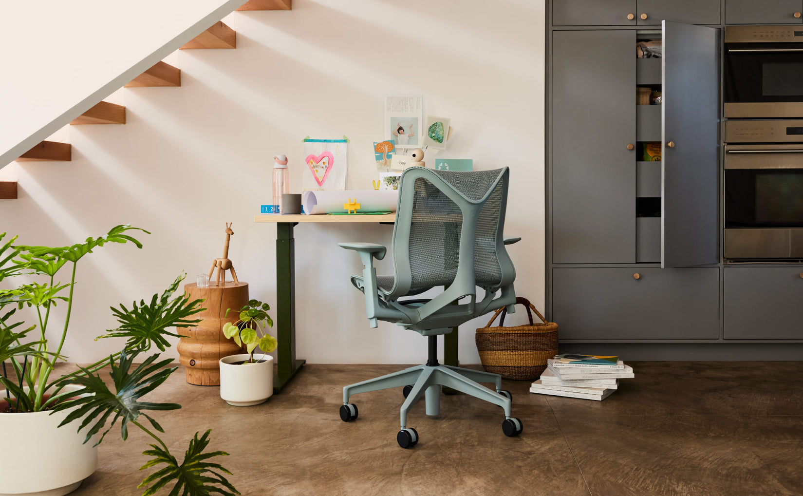 Espace de bureau à domicile sous un escalier avec un siège Cosm à dossier bas gris glacier devant un bureau compact assis-debout