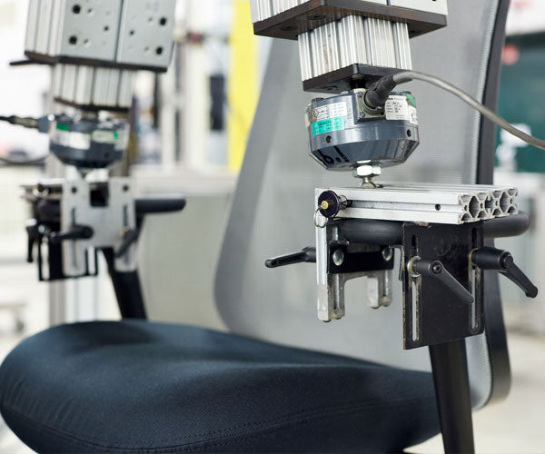 Photo du test à double bras qui reproduit le poids, la pression et l'usure auxquels sont soumis tous les fauteuils Herman Miller.