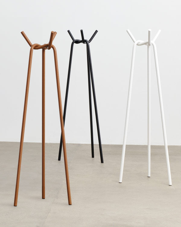 Trois porte-manteaux en tricot de HAY, présentant les trois couleurs disponibles : caramel, noir et blanc.