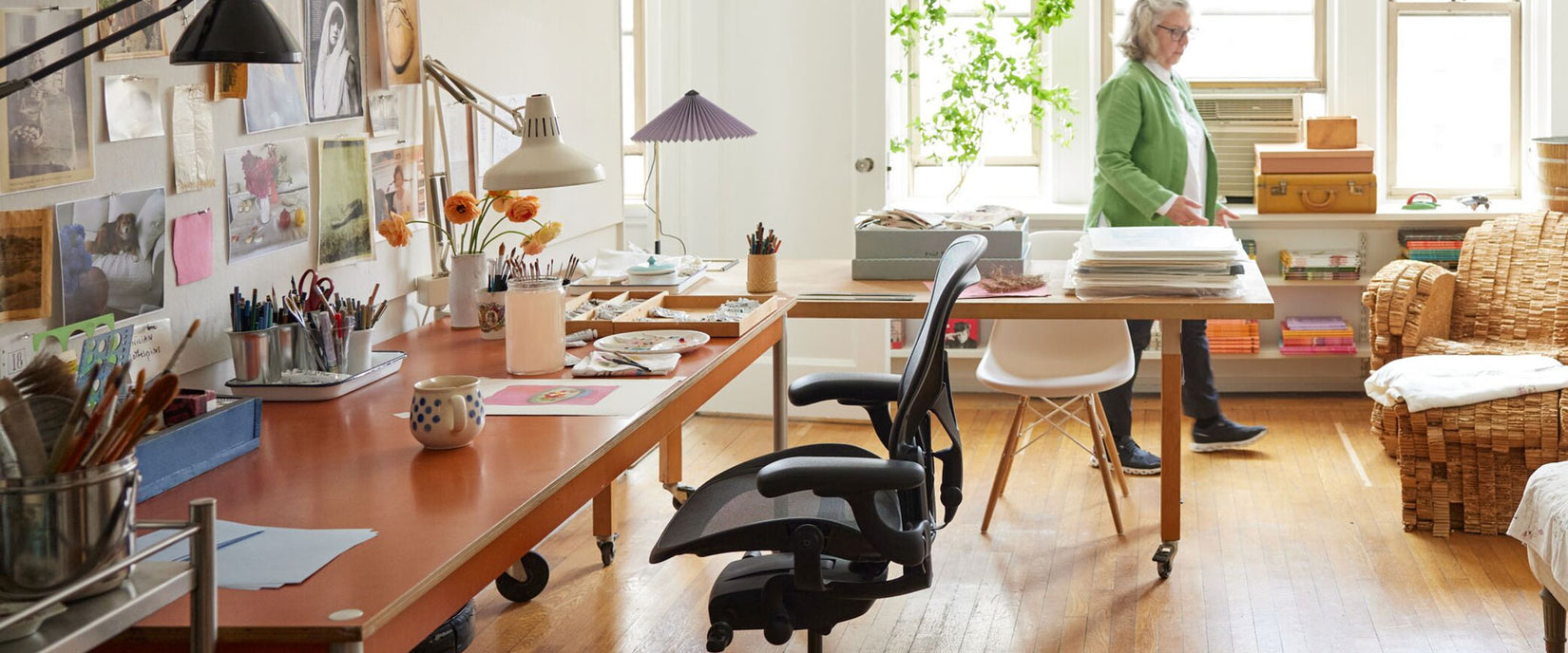 Photo de l'atelier de l'artiste Maira Kalman contenant une chaise de bureau Aeron en graphite et une lampe de table Hay Matin