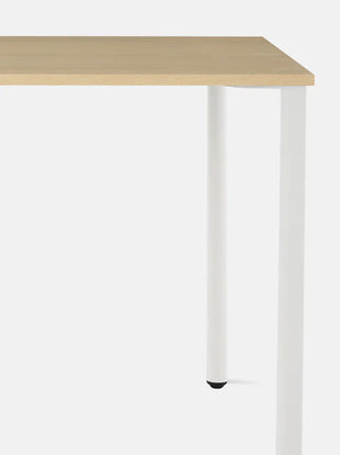 Gros plan de face d'un bureau OE1 blanc et cendre de Herman Miller, montrant le plateau durable et facile à nettoyer.