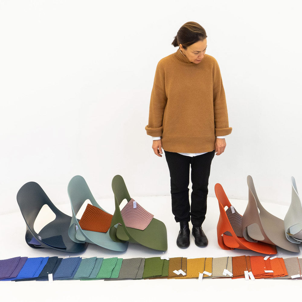 Designer de Studio 7.5 regardant vers le sol les échantillons de matériaux et les sièges Zeph dans différentes couleurs