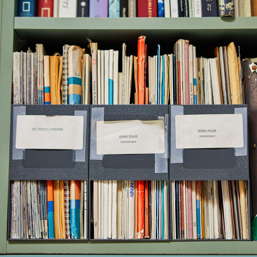 Image d'une étagère avec des dossiers de conception et de recherche liés à la conception et au développement des produits Herman Miller